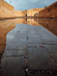 Reflection of old building in puddle on street