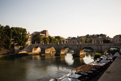 Arch bridge over river against clear sky