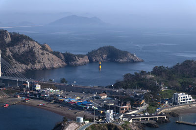 High angle view of sea by city against sky