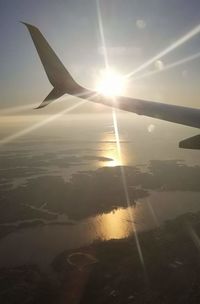 Airplane flying in sky at sunset