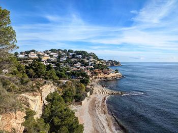 Aerial view of townscape by sea against sky