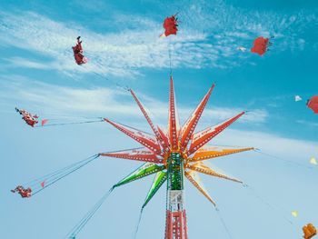 Low angle view of chain swing ride against sky