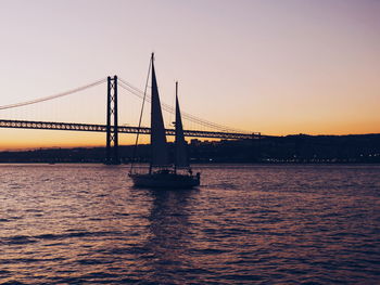 Silhouette boat on sea against clear sky during sunset