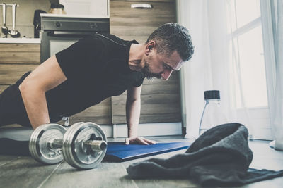 Sporty young man working out and trains at home. fit boy doing push-ups exercises.  health sport gym