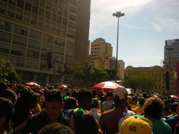 People on street in city against sky