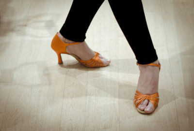 Low section of woman dancing on wooden floor