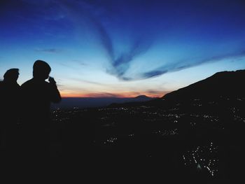 Silhouette man standing against sky at sunset