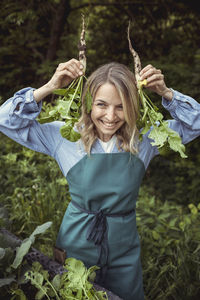 Smiling woman holding vegetable