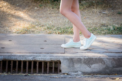 Low section of woman standing on footpath