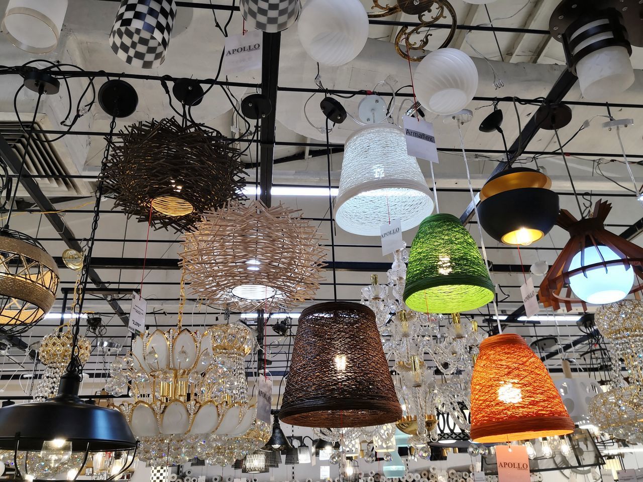 LOW ANGLE VIEW OF ILLUMINATED PENDANT LIGHTS HANGING FROM CEILING