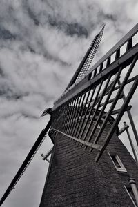 Low angle view of windmill against cloudy sky