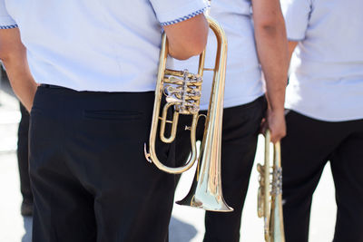 Midsection of men with trumpets