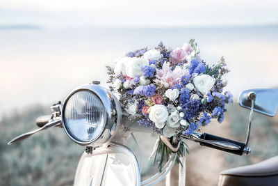 A large beautiful bridal bouquet of white roses and peonies is lying on a retro bike.