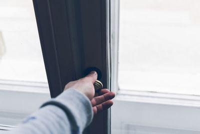 Cropped hand of person holding window knob