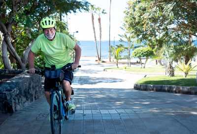 Smiling man riding bicycle in park