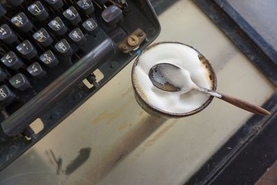 High angle view of coffee cup with typewriter on table