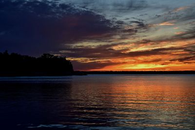 Scenic view of sea against cloudy sky at sunset