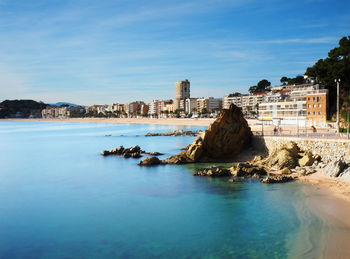 Scenic view of sea by buildings against sky