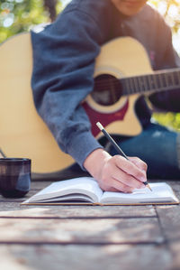 Midsection of man reading book on table