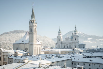 Salzburg cathedral and surrounding churches covered in snow on a sunny winter day