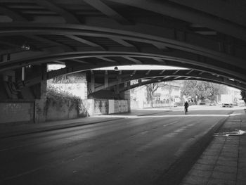 Man walking on bridge in city