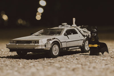 Tilt-shift image of toy car on road at night