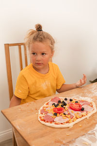 Portrait of girl sitting on table