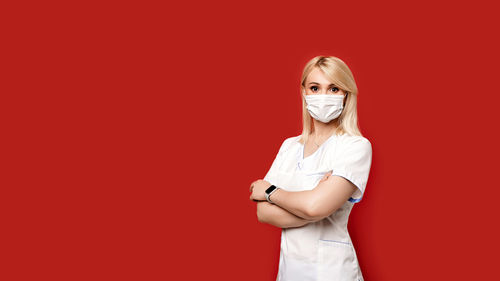 Portrait of a young woman against red background