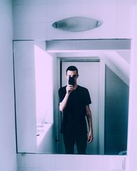 Young man wearing sunglasses standing in corridor