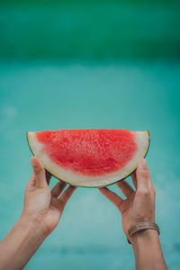 Watermelon held up outside during a hot and sunny day.