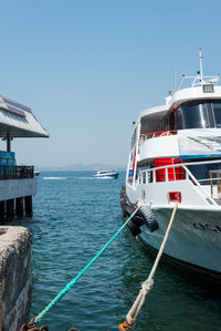 Sailboats moored on sea against clear sky