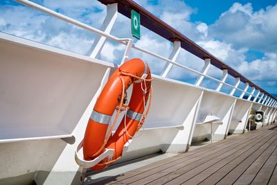 Life belt on boat against cloudy sky