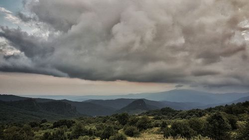 Scenic view of mountains against cloudy sky