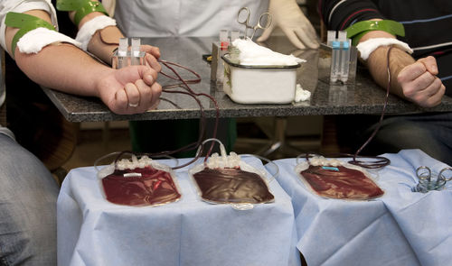 Cropped image of people donating blood at hospital