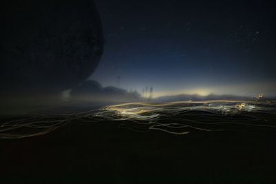 Aerial view of illuminated light trails against sky at night