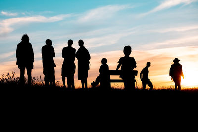 Silhouette people standing against sky during sunset