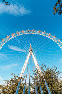 Low angle view of ferris wheel against blue sky