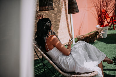 Rear view of woman sitting outdoors