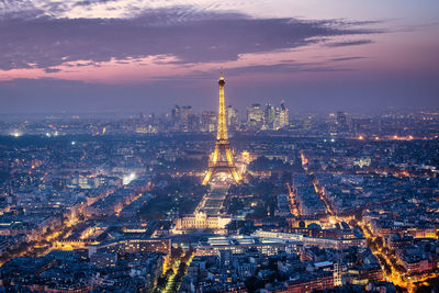 Aerial view of city lit up at sunset