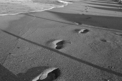 High angle view of footprints on sand at beach