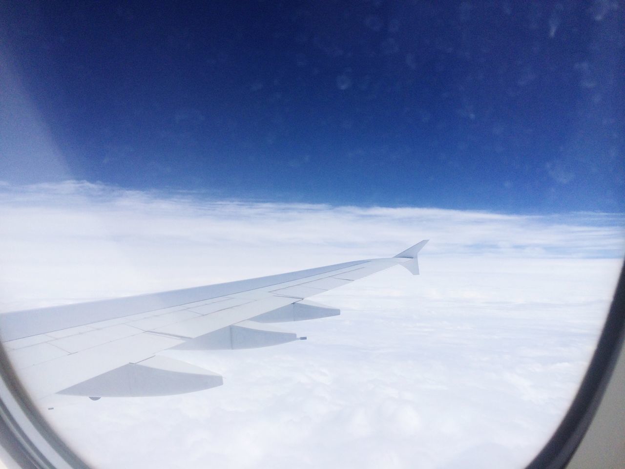 CROPPED IMAGE OF AIRPLANE WING OVER LANDSCAPE