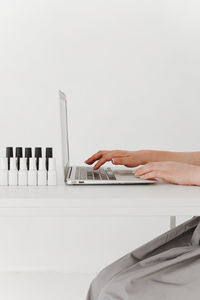 Cropped hands of woman using laptop on table