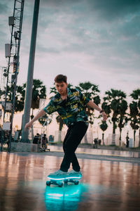 Portrait of young man in swimming pool against sky