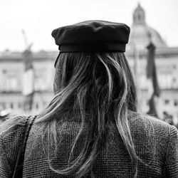 Rear view of woman with umbrella in city