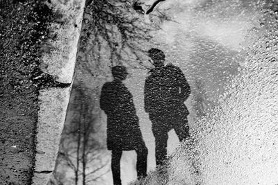 People walking on wet street in city