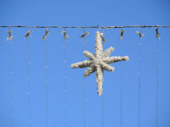Low angle view of christmas decoration against blue sky