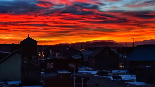 Houses in town against sky during sunset