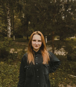 Portrait of beautiful young woman standing in forest