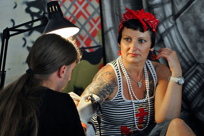 Artist making tattoo on woman hand