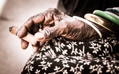 Midsection of senior woman holding cigar